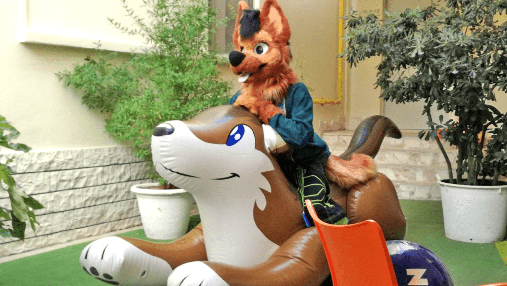 Fursuiter (Nicky German) sopra un lupo gonfiabile